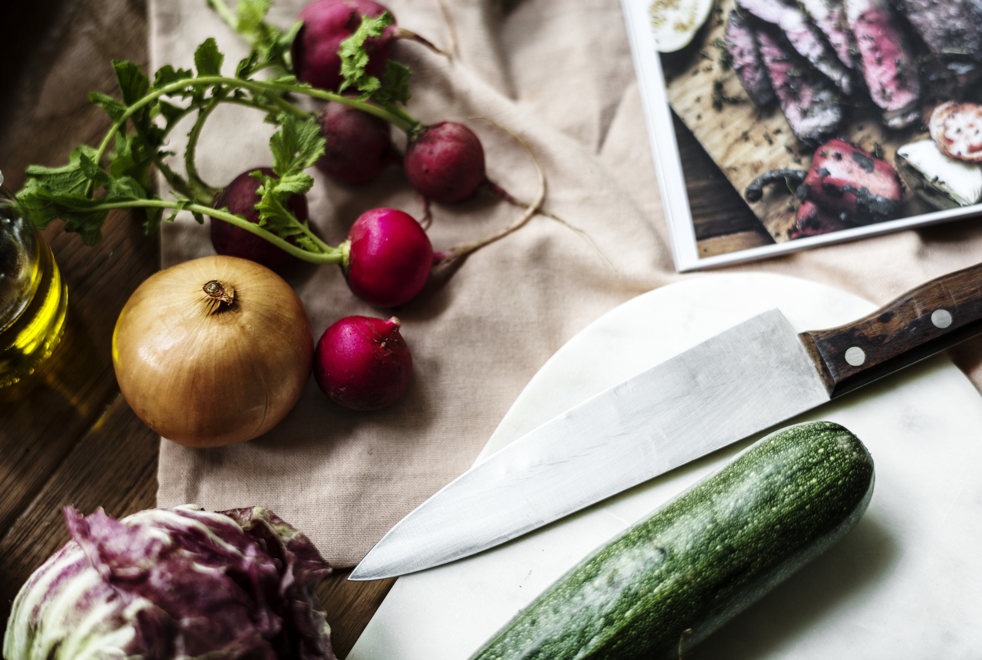 Close-up of heirloom vegetables on linen with artisan knife